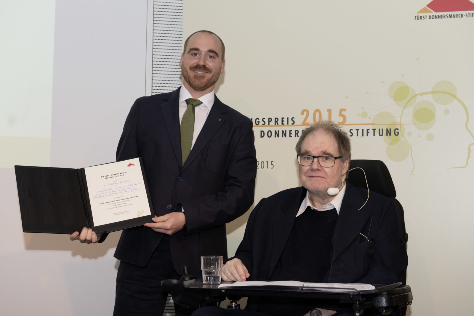 Christian Schlenstedt und Prof. Wegscheider bei der Forschungspreisverleihung 2015. Christian Schlenstedt hält die Urkunde seiner Belobigung in den Händen