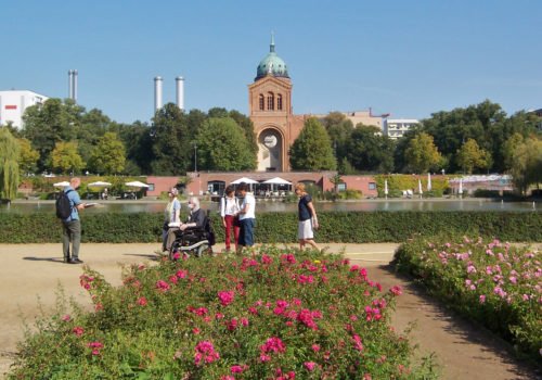 Blumenbeete am Luisenstädtischen Kanal mit einer Spaziergruppe im Rolli