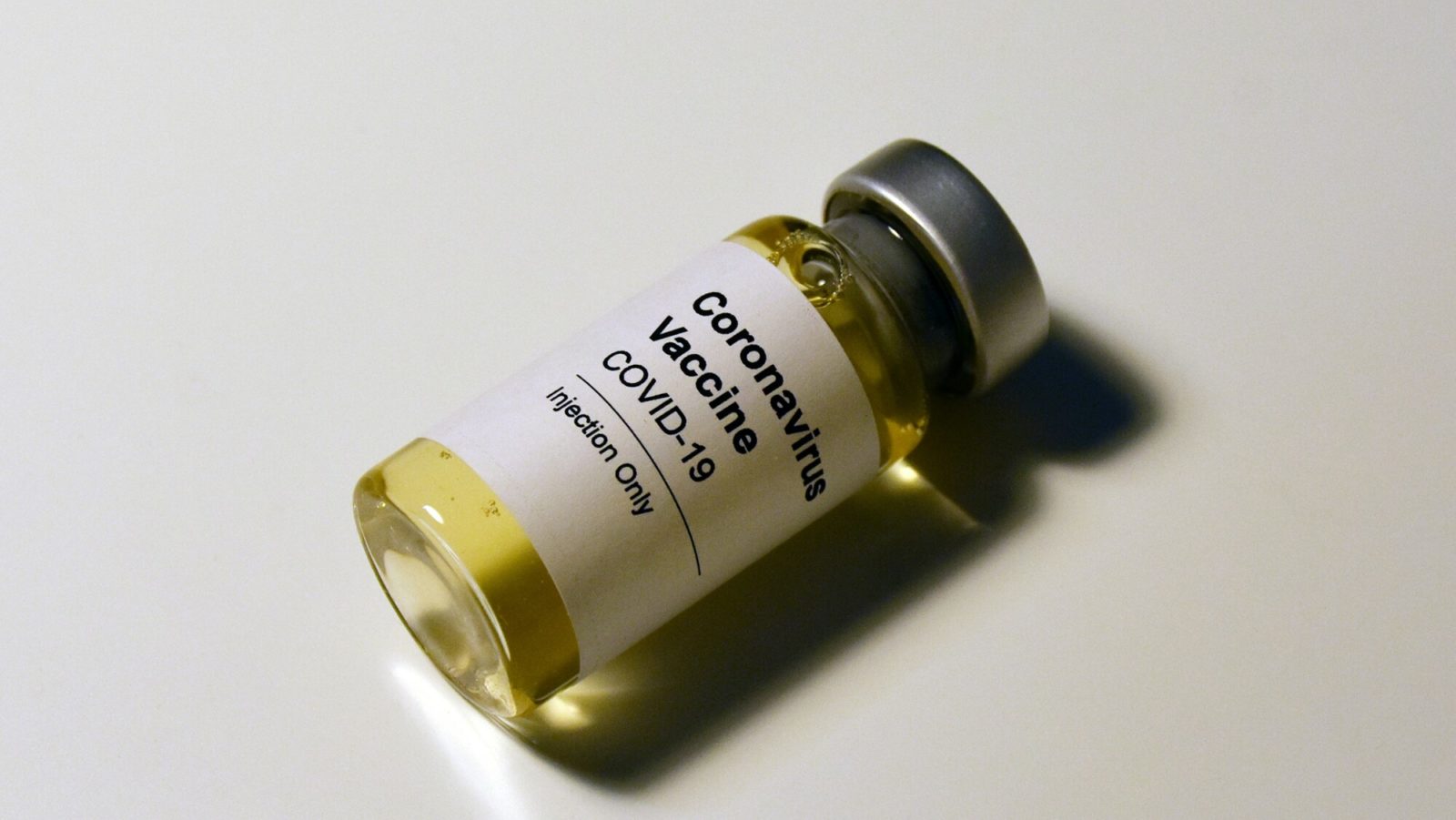 Symbolfoto: Eine medizinische Ampulle mit der Aufschrift Covid-19 Vaccine.