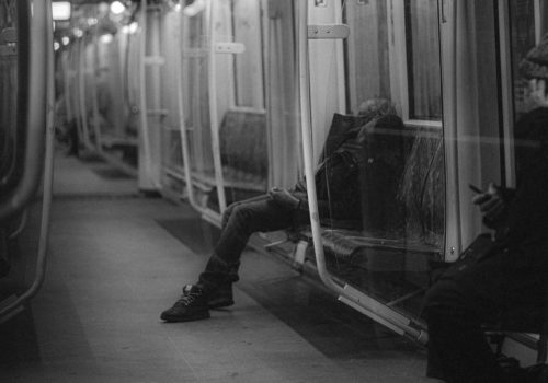 Schwarz-Weiß Foto aus der Berliner U-Bahn Ein Mann schläft auf der Sitzbank.